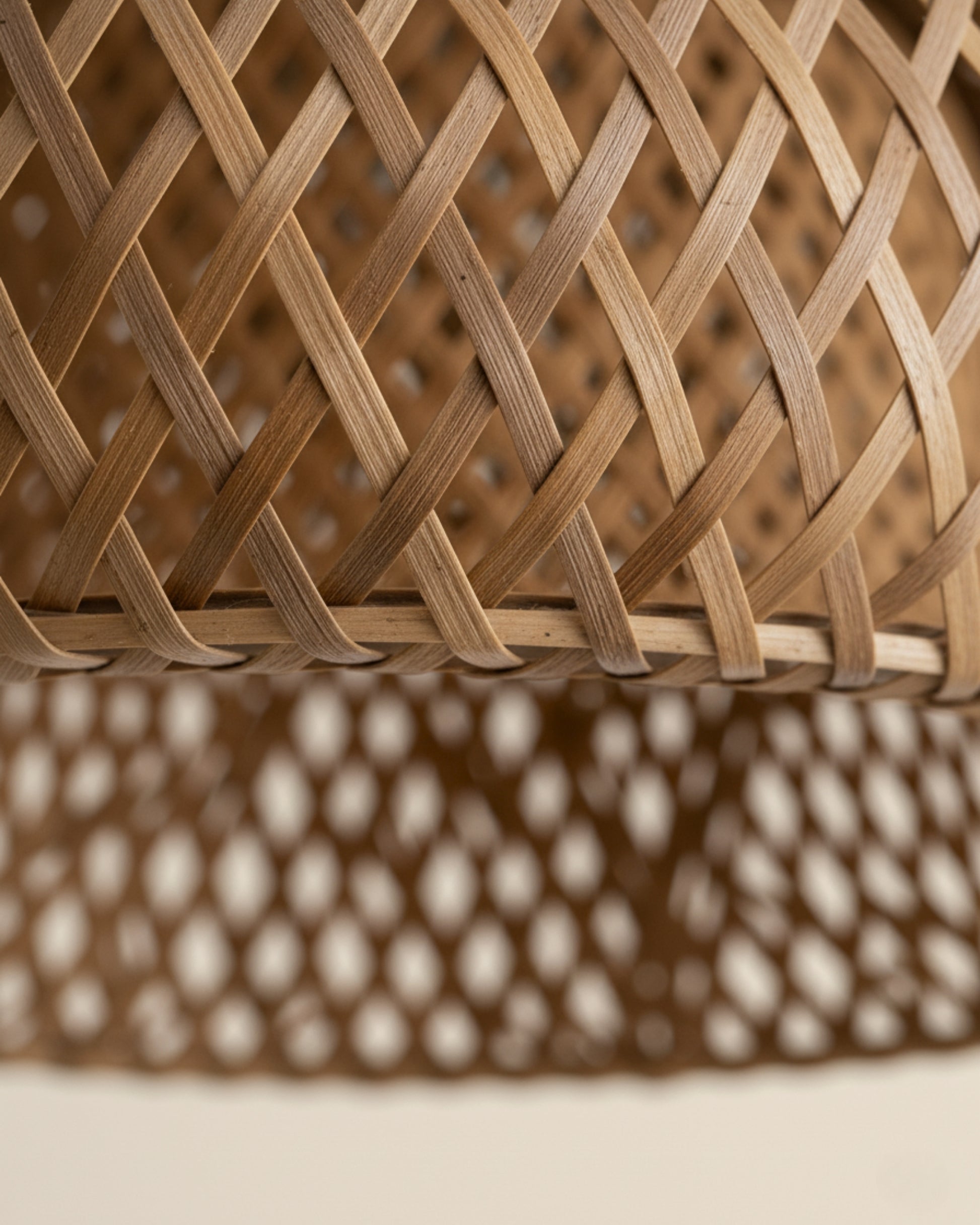 Close-up of handwoven bamboo lattice lampshade; natural grain and honey-brown tone with even diamond weave. Edge binding detail visible, soft studio lighting and shallow depth of field.