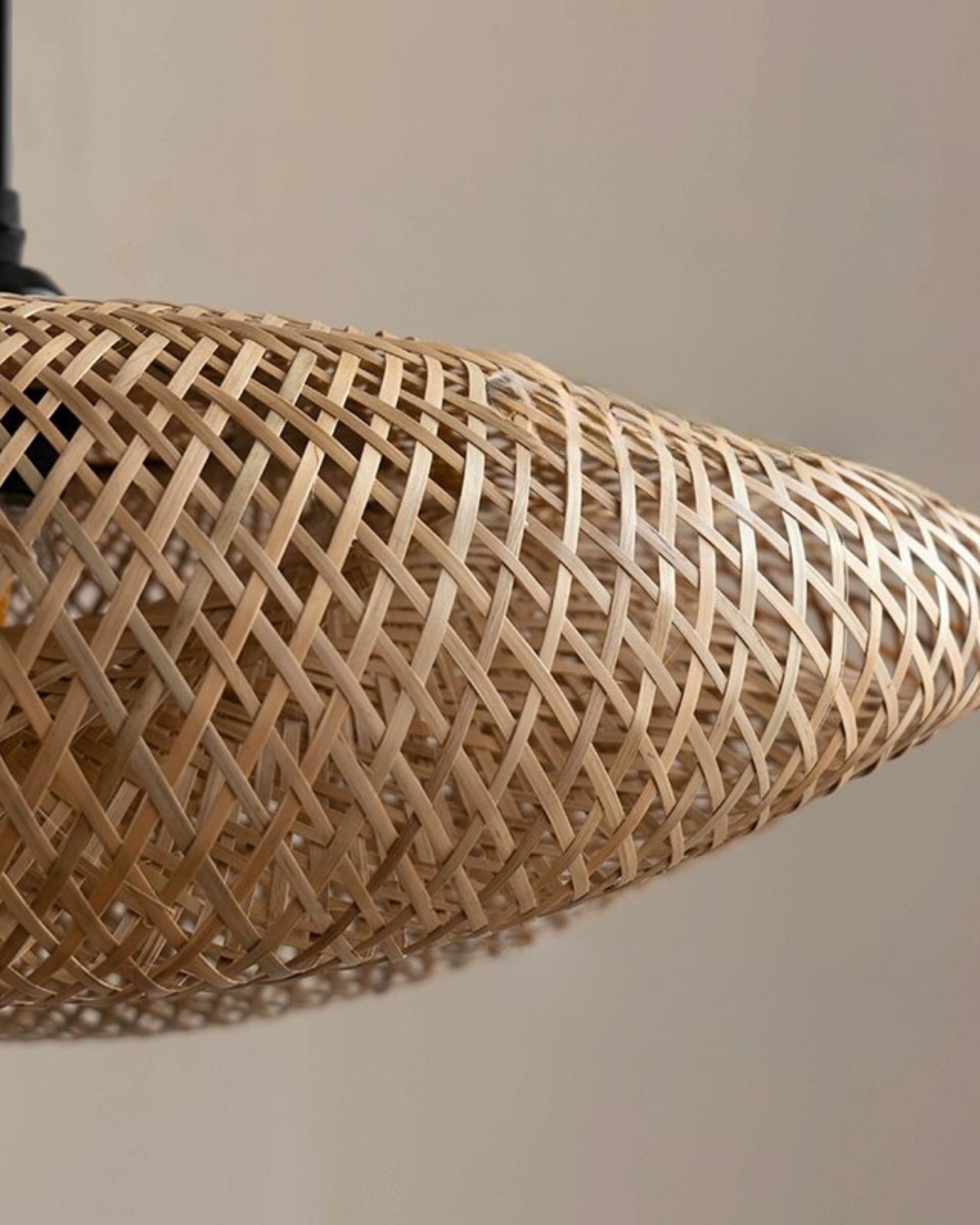 Macro close-up of a handwoven bamboo twisted-disc pendant shade, showing the crisscross lattice texture; natural rattan tone with black fitting; lamp OFF in daylight; ideal over a kitchen island or dining table in Japandi/Scandinavian homes.
