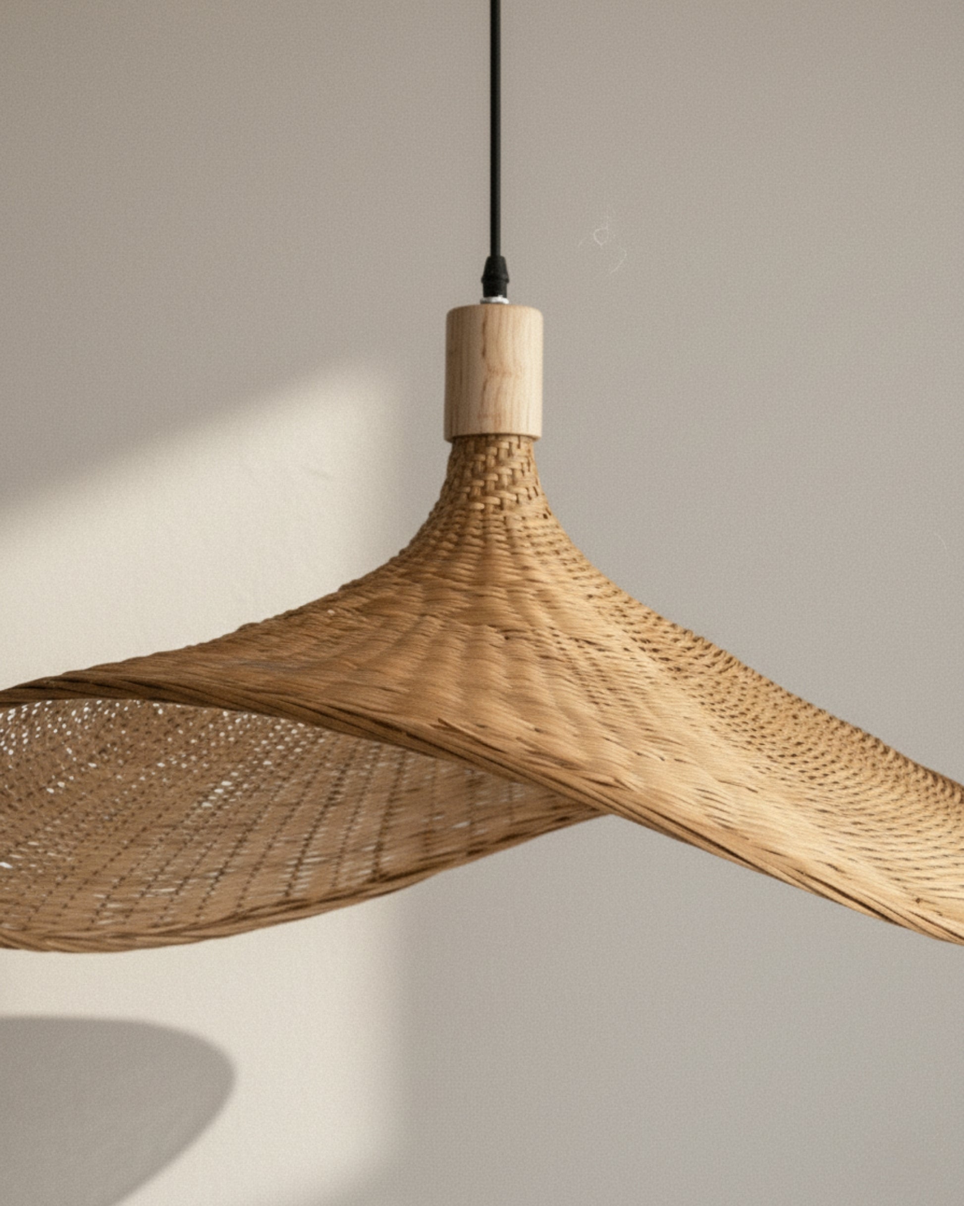 Side view of a handwoven rattan pendant light with a sculptural wave shade and wood cap; airy weave casts a soft wall shadow—ideal over a kitchen island or dining table; E27 LED compatible.