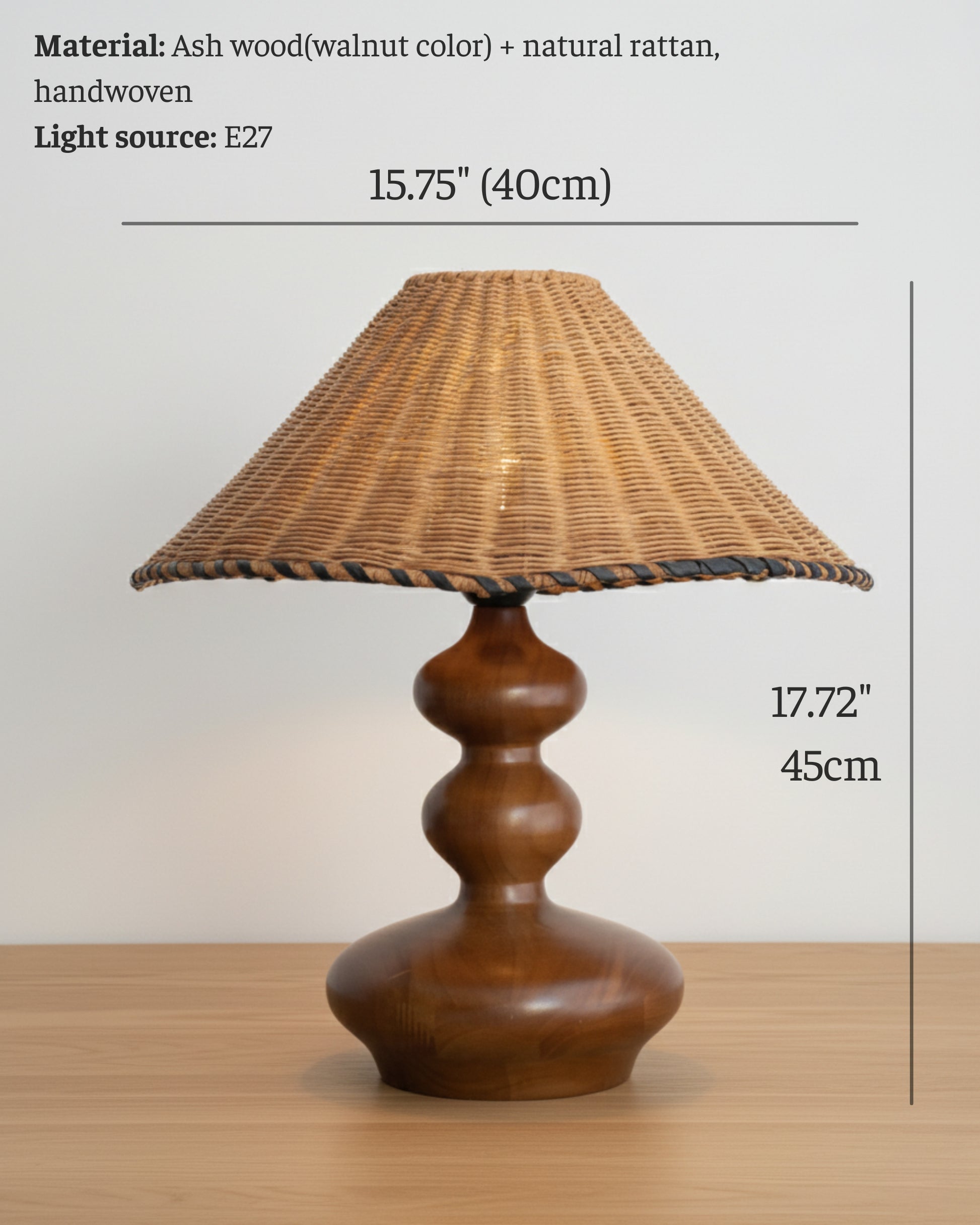 Product infographic of a handwoven rattan table lamp with ash-wood base (walnut tone) and E27 socket; shows dimensions—40 cm (15.75") shade diameter and 45 cm (17.72") overall height—on a light wood tabletop.